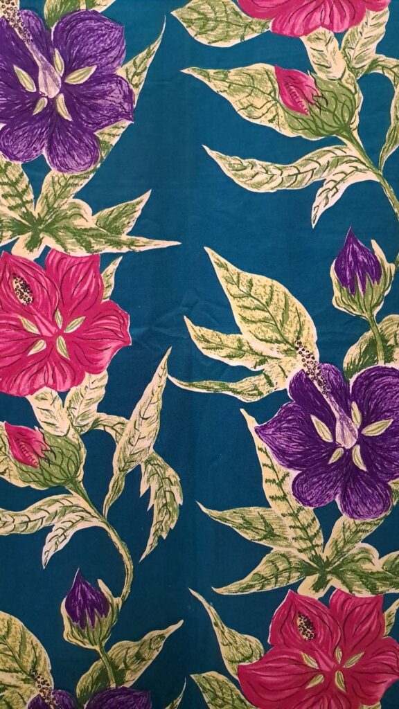 Althea McNish textile of flowers and leaves with teal blue background and pink and purple flowers.
