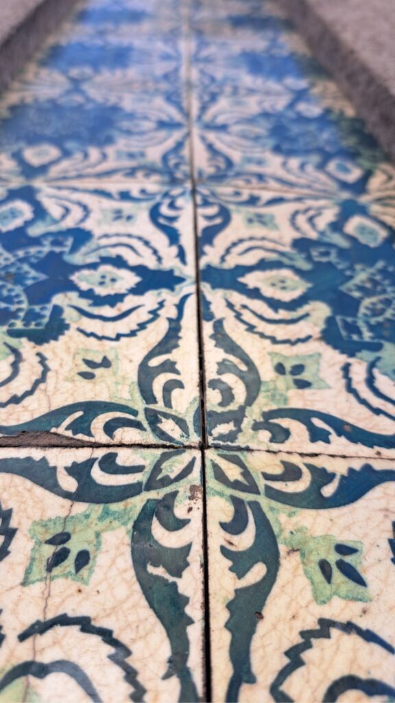 Wall tiles close up in Portugal. Cream background with soft green and lapis blue details.