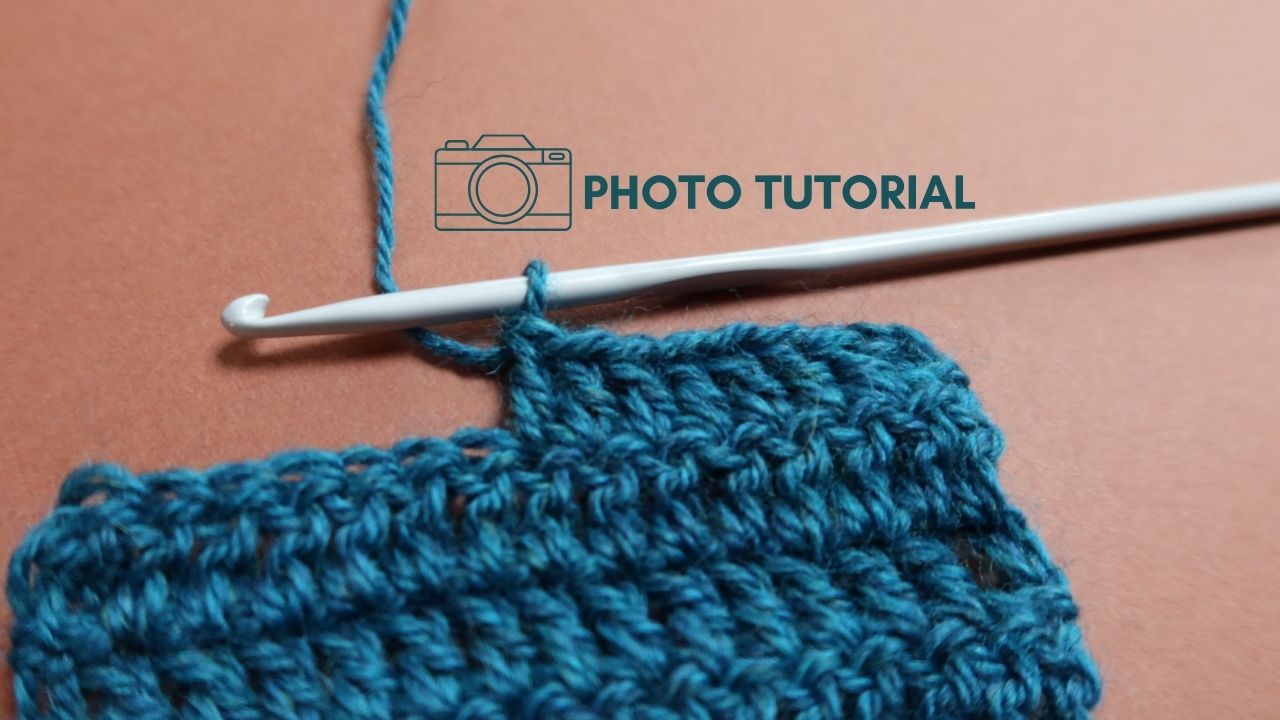 Close up of treble crochet stitches in teal yarn with hook.