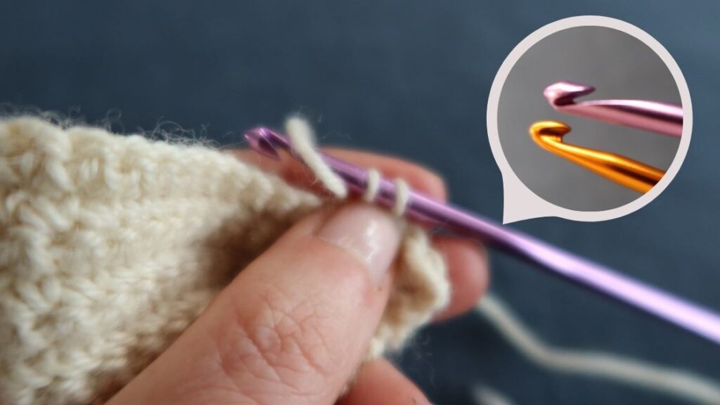 Close up of a yarn under double crochet being made by pinching the loops of the hook together.  