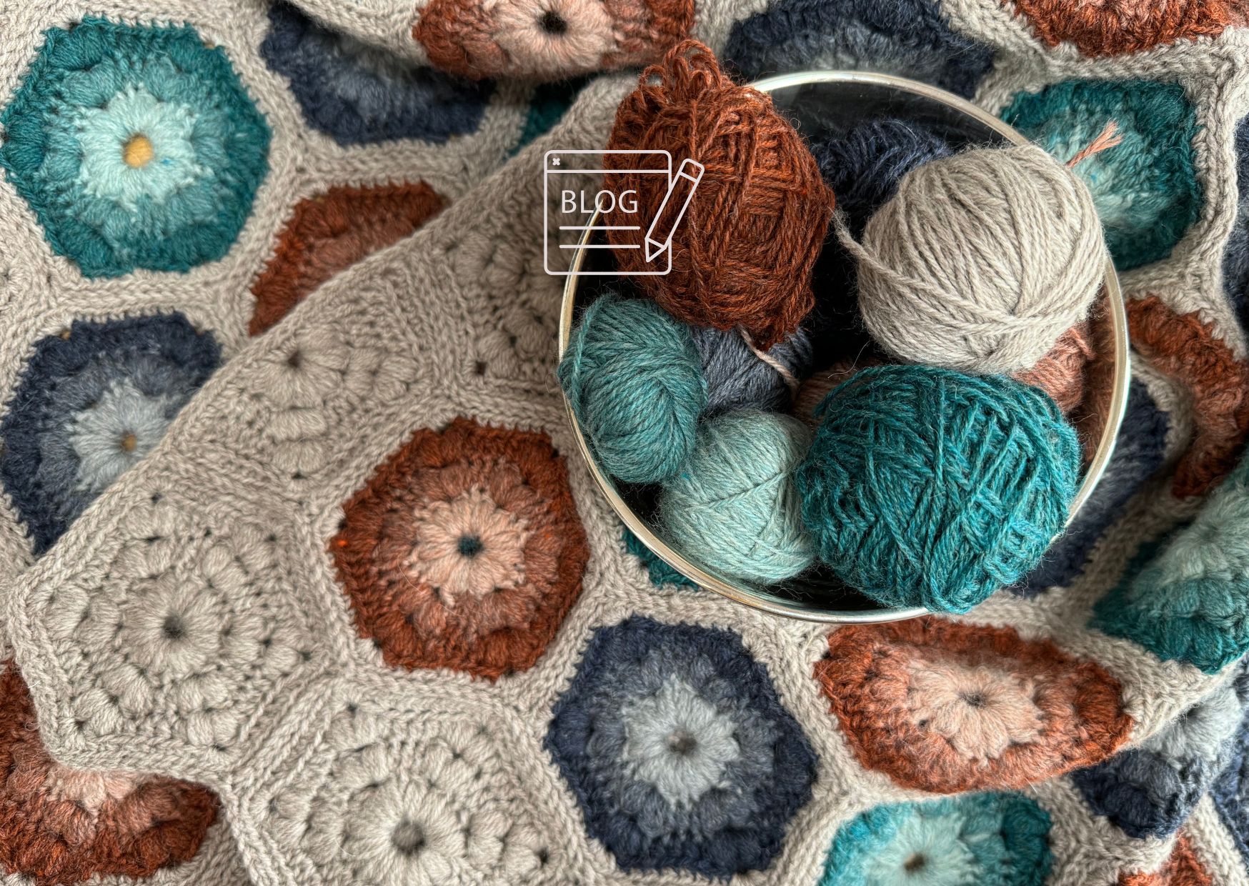 Crocheted blanket with lots of hexagon motifs and colour changes in each round.