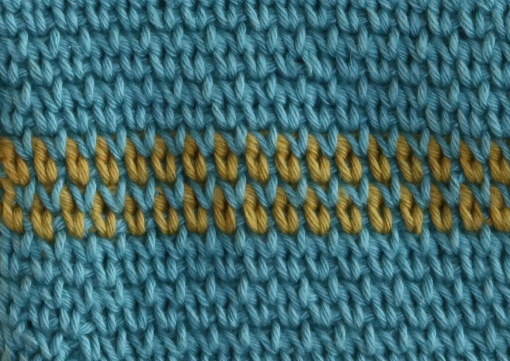 Close-up of blue and gold crocheted waistcoat stitch fabric