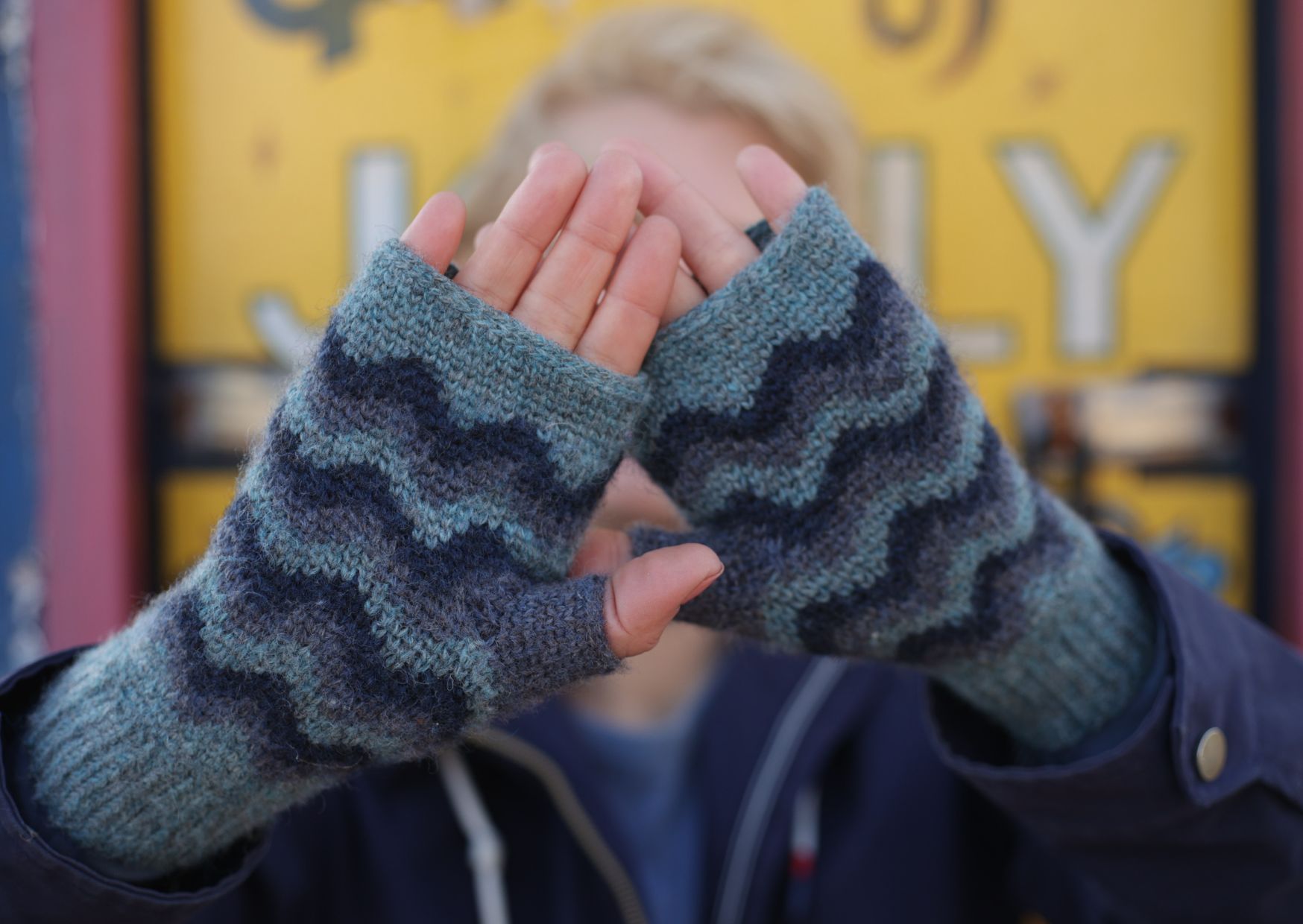 Crocheted open mittens in waistcoat stitch with waves in three different shades of blue.