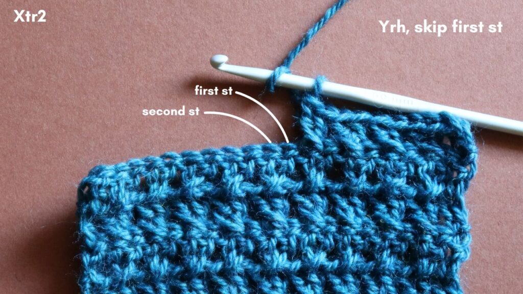 Close up of the skipped stitch and next stitch tow be worked in a 2 crossed treble crochet.