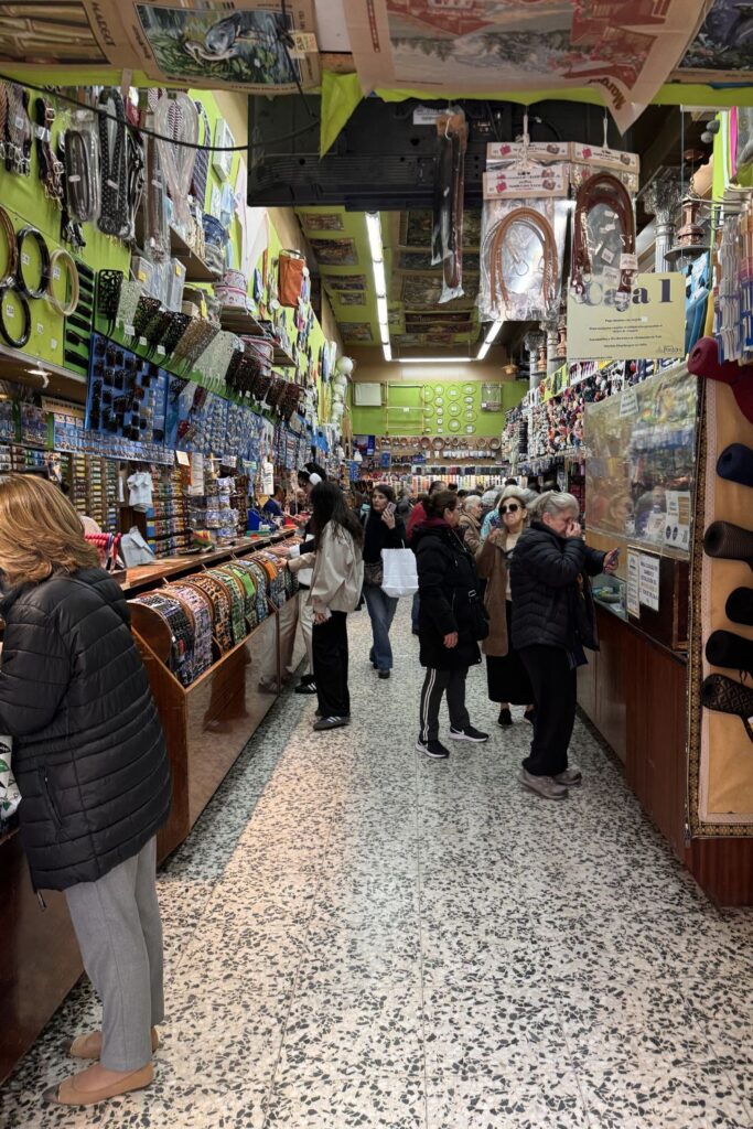 People browse colorful yarn and craft supplies in a Madrid shop.