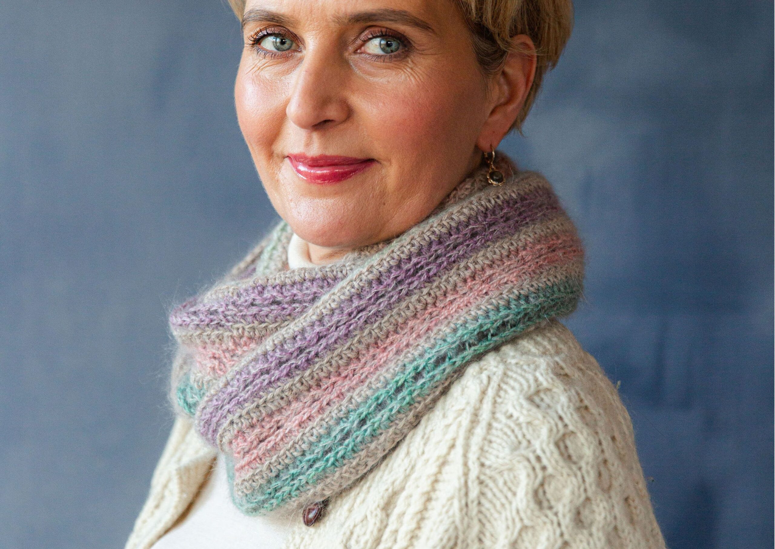 Woman wearing pastel striped crocheted cowl that has a halo of mohair.
