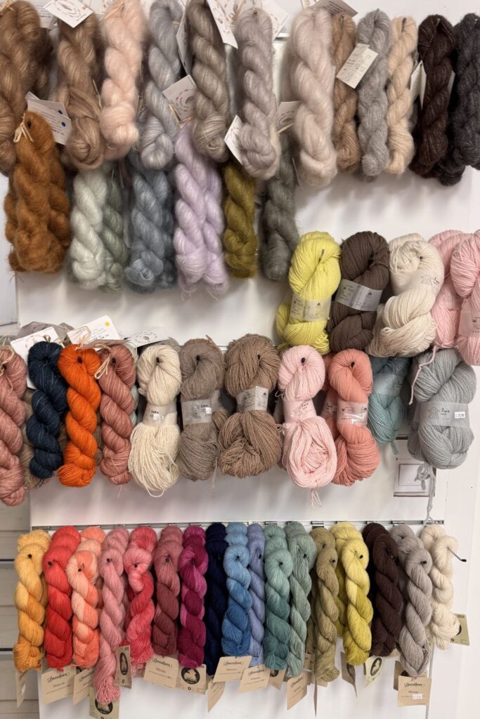 Skeins of hand dyed yarn hung in a yarn shop.