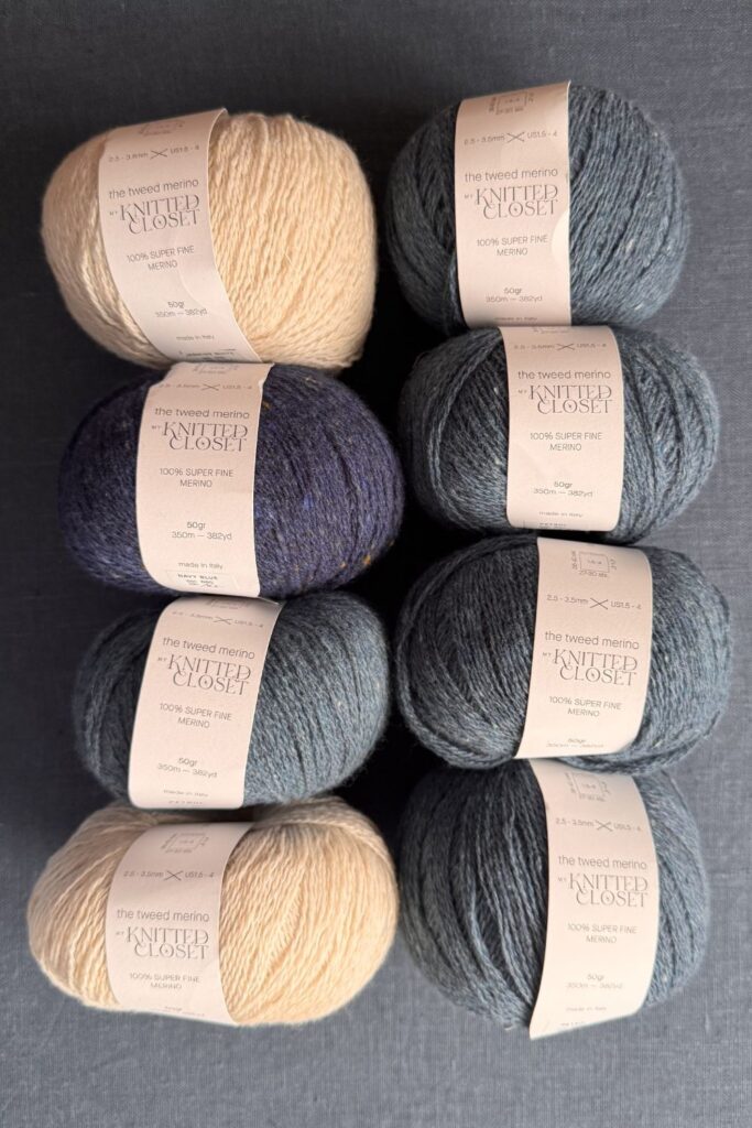 Balls of tweedy yarn in nay, denim blue and off white. 