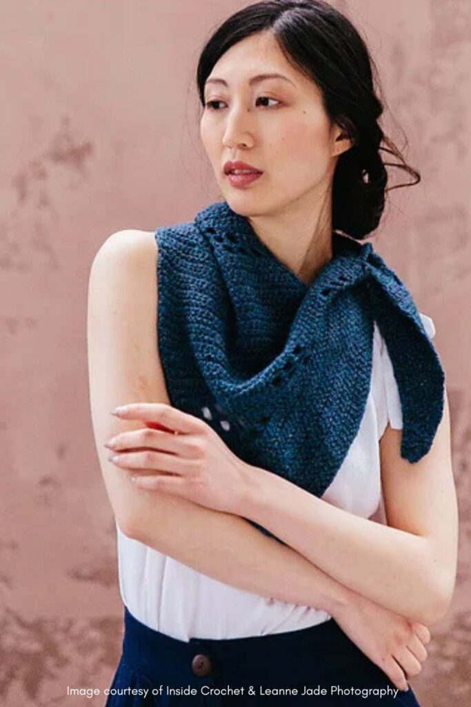 Asymetric triangle crochet filet shawl being worn on model.