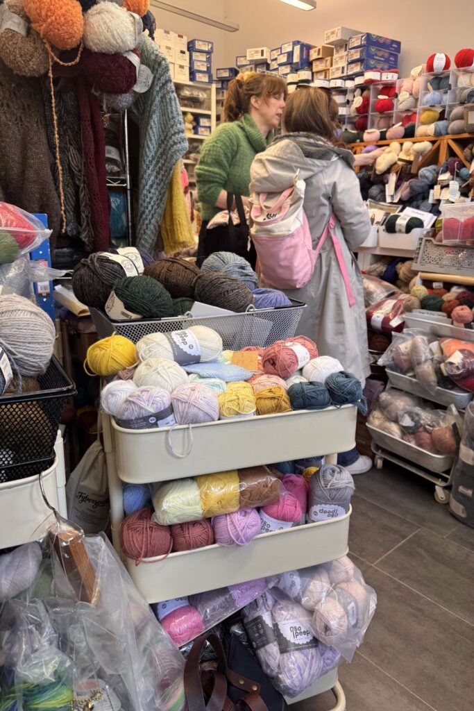 Trolleys and shelves and bags full of yarn bursting out in Be Inspired Fibres.