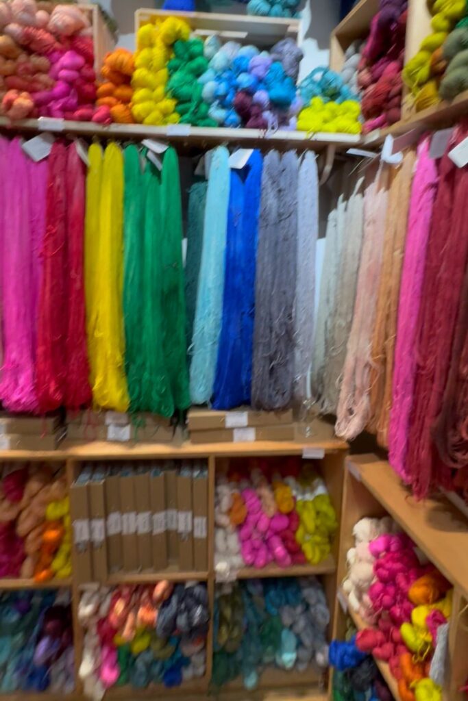 Lots of yarn hanging on pegs on the wall of Ginger Twist Studio yarn shop.
