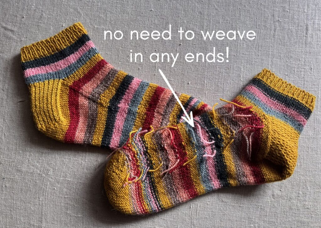 A pair of brightly coloured knitted striped trainer socks with no sew coloured yarn join method.