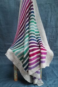 Striped knitted blanket pattern in light grey with earthy Scottish coloured stripes.