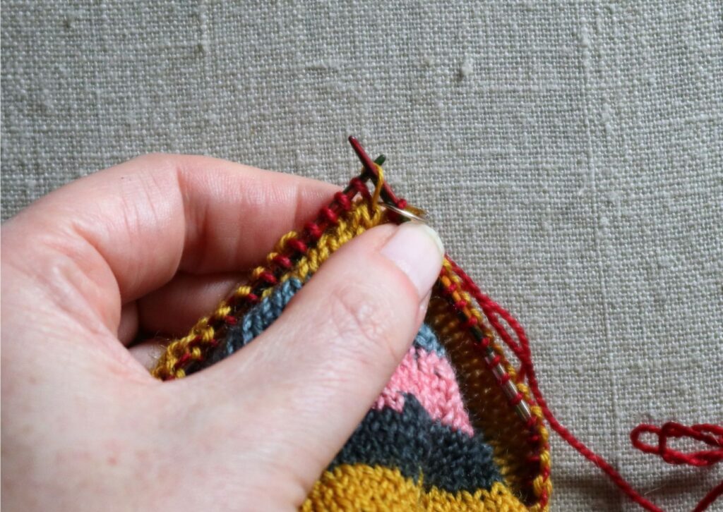 Close up of stripy trainer socks being knitted.
