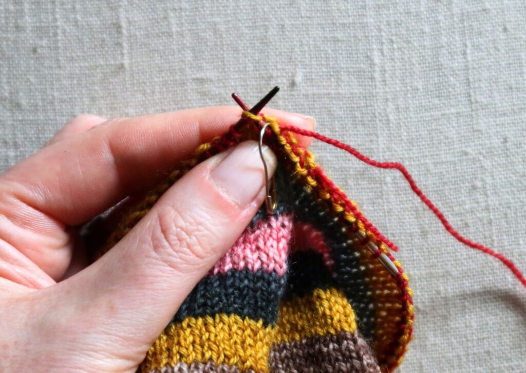 Close up of stripy trainer socks being knitted.