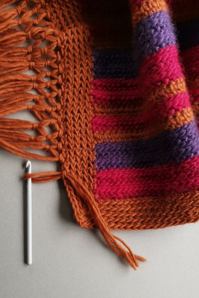 Retro striped crochet blanket with knotted fringe.