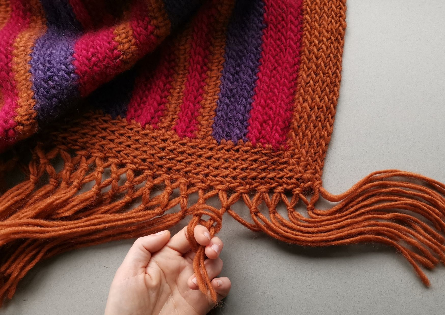 Retro striped crochet blanket with knotted fringe.